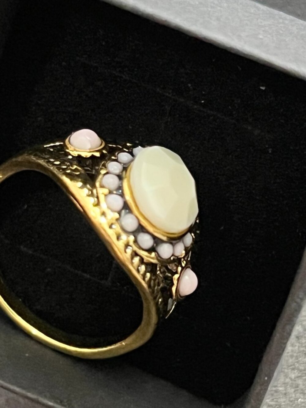 Vintage\-style gold\-tone statement ring featuring a faceted cream center stone